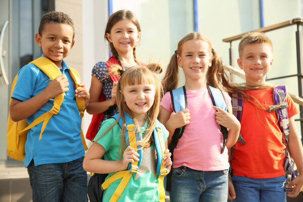 Cute little children with backpacks outdoors. Elementary school