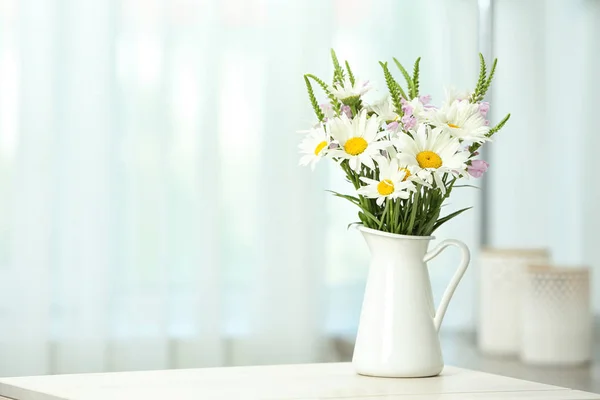 背景をぼかした写真に対してテーブルの上の野生の花と花瓶 — ストック写真