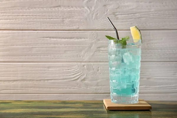 Glas Mit Leckeren Cocktails Und Eiswürfeln Auf Tisch Vor Holzhintergrund — Stockfoto