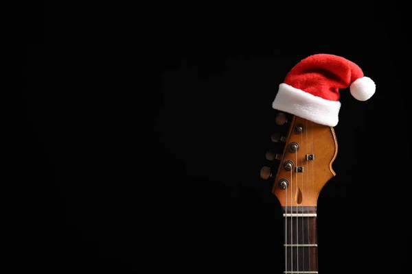 Gitaar Met Kerstmuts Zwarte Achtergrond Kerst Muziek Concept — Stockfoto