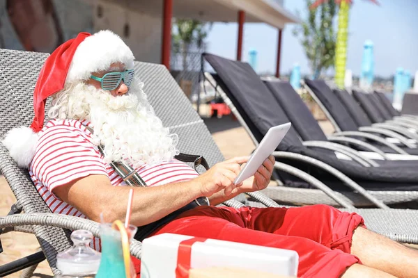 Autentyczny Święty Mikołaj Pomocą Tabletu Leżaku Resort — Zdjęcie stockowe