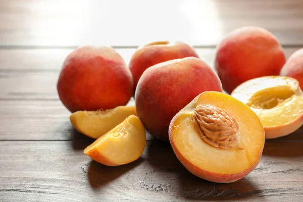 Fresh sweet peaches on wooden table, closeup