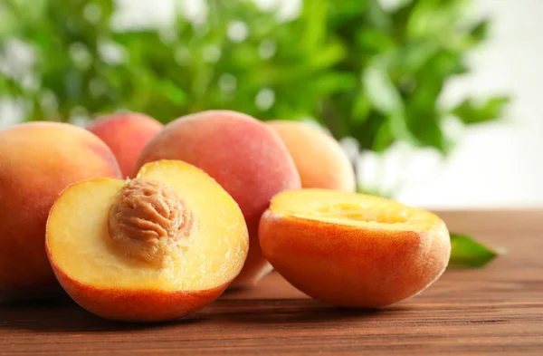 Fresh sweet peaches on wooden table, closeup