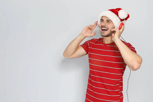 Jeune Homme Chapeau Santa Écouter Musique Noël Sur Fond Couleur — Photo