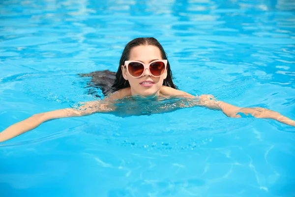 青いプールで泳ぐ美しい若い女性 — ストック写真