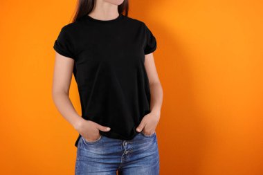 Renk arka plan üzerinde siyah t-shirt bir genç kadın. Mockup tasarım için