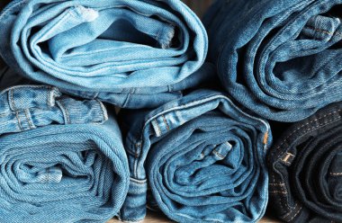 Farklı renklerde arka plan olarak haddelenmiş kot pantolon