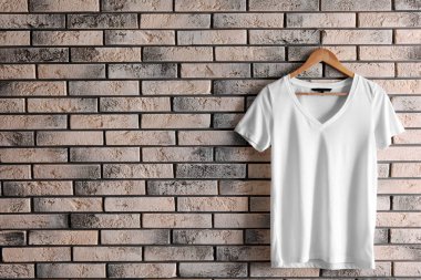 Askı ile boş t-shirt tuğla duvar üzerine. Mockup tasarım için