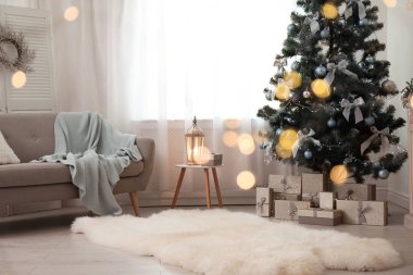 Şık salon iç ile dekore edilmiş Noel ağacı ve bulanık ışıklar ön planda