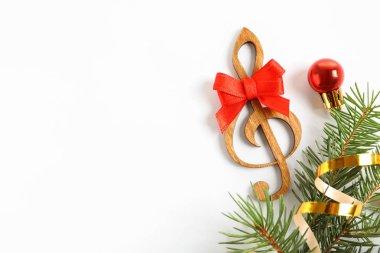 Ahşap tiz nota anahtarı ve süslemeleri beyaz arka plan üzerinde. Noel müzik konsepti