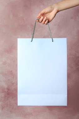 Kağıt alışveriş çantası renk arka plan üzerinde tutan kadın