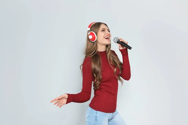 Νεαρή Γυναίκα Τραγουδάει Στο Μικρόφωνο Στο Χρώμα Φόντου Χριστουγεννιάτικη Μουσική — Φωτογραφία Αρχείου