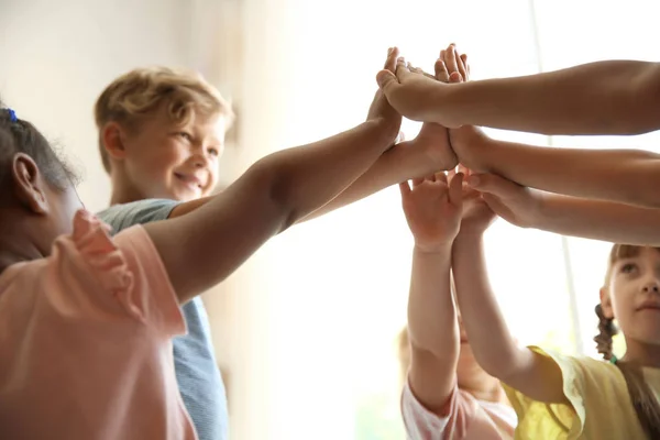 Crianças Pequenas Juntando Mãos Fundo Claro Conceito Unidade — Fotografia de Stock