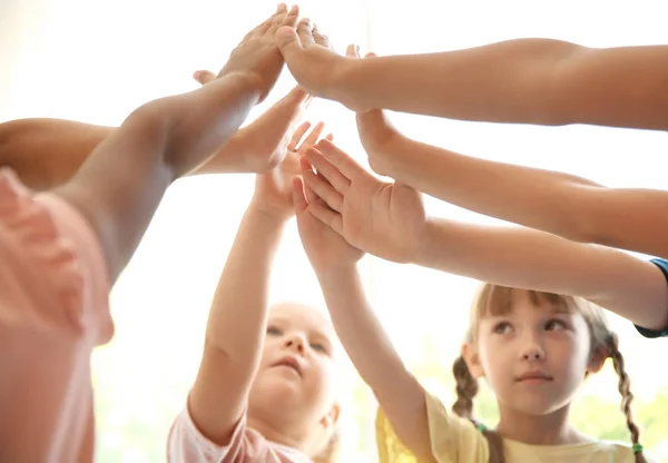 Niños Pequeños Poniendo Sus Manos Juntas Sobre Fondo Claro Concepto — Foto de Stock