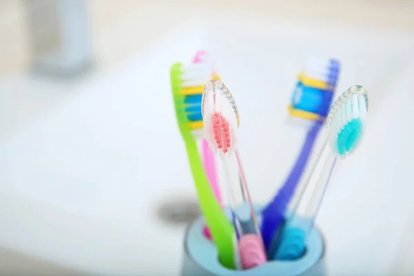 Copo Com Escovas Dentes Diferentes Perto Pia Close Cuidados Dentários — Fotografia de Stock