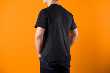 Renk arka plan üzerinde siyah t-shirt genç adam. Mockup tasarım için