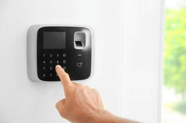Olgun adam kapalı alarm sistemi tuş takımında kodunu girme