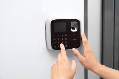 Genç adam kapalı alarm sistemi tuş takımında kodunu girme