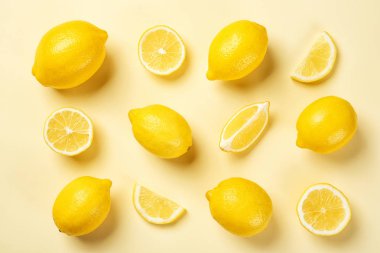 Renk arka plan üzerinde tüm ve dilimlenmiş limon ile düz yatıyordu kompozisyon