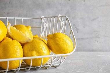 Açık renkli karşı masada olgun limon ile metal sepet
