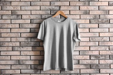 Askı ile boş t-shirt tuğla duvar üzerine. Mockup tasarım için