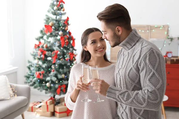 幸せな若いカップルの家でクリスマスを祝うシャンパン グラス — ストック写真