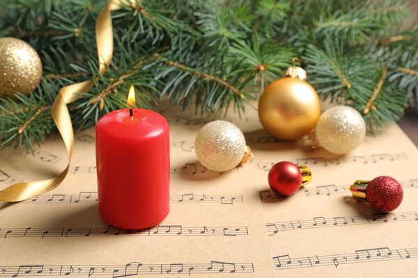 Composition with Christmas decorations and music sheets on table
