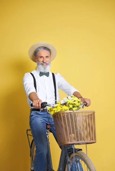 色の背景上の自転車とハンサムな中年の男性の肖像画 — ストック写真