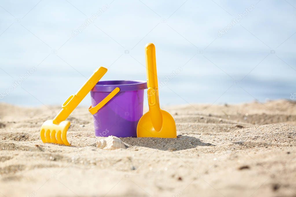 Children toys on sand near sea. Beach object