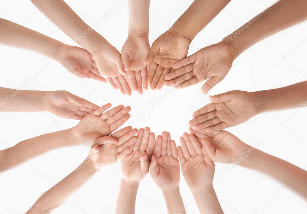 Little children putting their hands together indoors, view from below. Unity concept