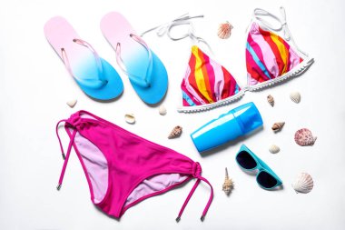 Beyaz arka plan üzerinde bikini ve plaj nesnelerle düz yatıyordu kompozisyon