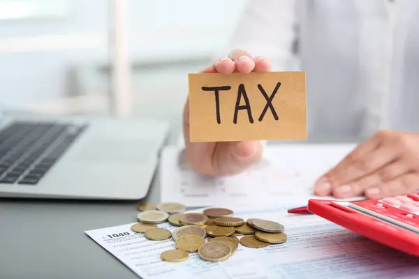 Mulher Segurando Cartão Com Palavra Tax Mesa — Fotografia de Stock