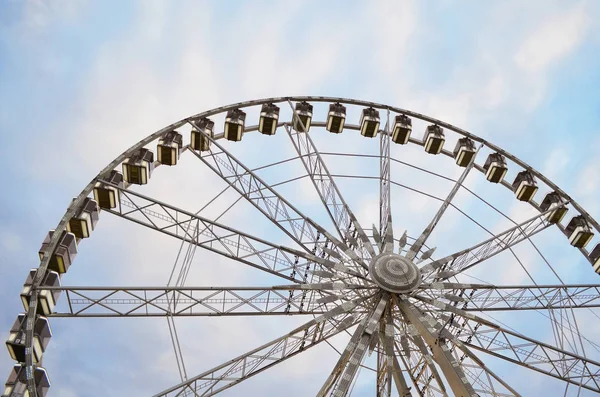 Large observation wheel on cloudy sky background