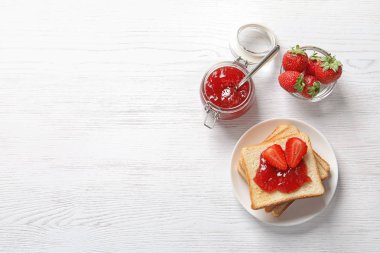 Tost ekmeği, çilek reçeli ve ışık arka plan üzerinde taze çilek ile düz yatıyordu kompozisyon