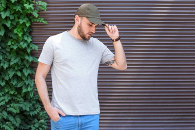 Sokakta duvarının yakınında gri t-shirt giyen genç adam. Kentsel tarzı