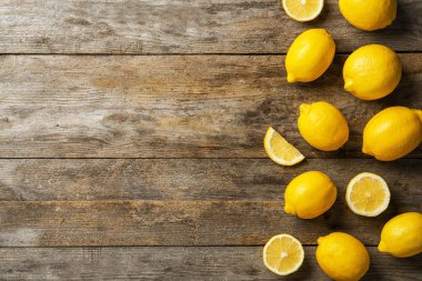 Ahşap arka plan üzerinde tüm ve dilimlenmiş limon ile düz yatıyordu kompozisyon