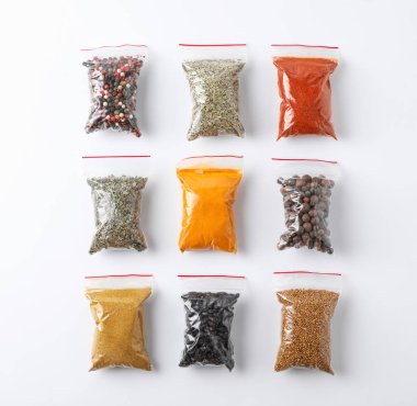 Beyaz arka planda, üstten görünüm farklı baharatlar ile plastik torbalar