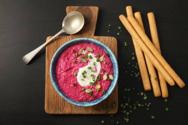 Kase lezzetli pancar humus ile kompozisyon yat ve koyu arka plan üzerinde sopa ekmek