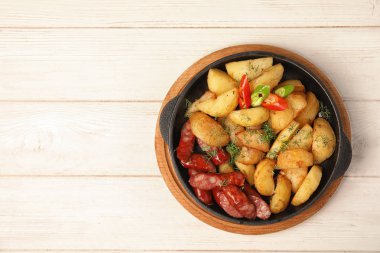 Patates kızartması ve ahşap masa, üstten görünüm üzerinde sosis tava