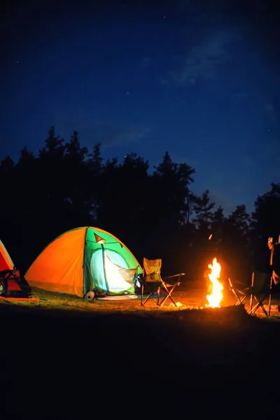 夜の荒野での焚き火の近くのキャンプのテントを輝く — ストック写真