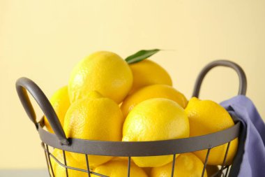 Renk arka plan üzerinde olgunlaşmış taze limon ile metal sepet