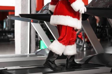 Otantik Noel Baba modern spor salonunda treadmill eğitim, ayak üzerinde odaklanmak