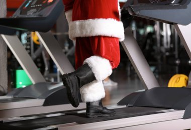 Otantik Noel Baba modern spor salonunda treadmill eğitim, ayak üzerinde odaklanmak