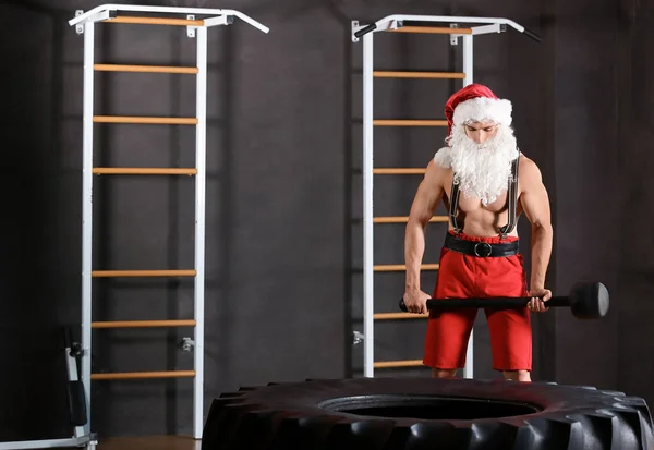 Young Muscular Man Santa Costume Hitting Heavy Tire Hammer Gym — Stock Photo, Image