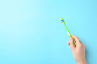 Renkli arka planı el ile diş fırçası tutan kadın