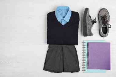 Okul kız ve defter üzerinde beyaz ahşap arka plan, en iyi görünüm için tek tip