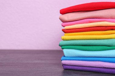 Tablo renkli arka plan üzerinde renkli tişörtler yığını