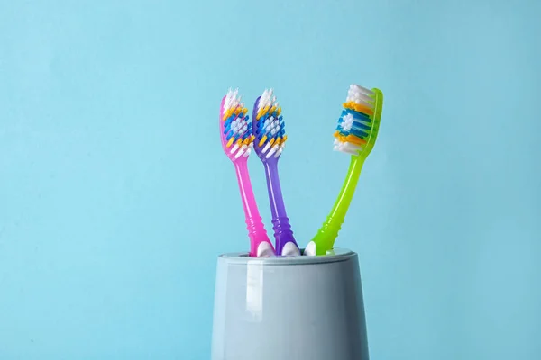 Tasse Mit Zahnbürsten Vor Farbigem Hintergrund — Stockfoto