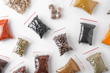 Beyaz arka planda, üstten görünüm farklı baharatlar ile plastik torbalar