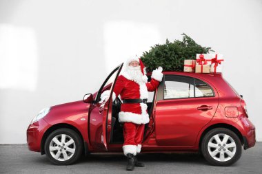 Otantik Noel Baba hediye kutuları ve Noel ağacı, açık havada kırmızı araba yakınındaki